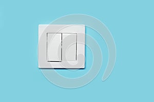 Modern plastic light switch on blue wall, space for text