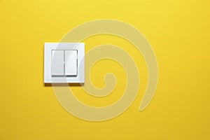 Modern plastic light switch on orange background. Space for text