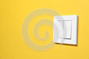 Modern plastic light switch on orange background. Space for text