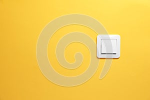 Modern plastic light switch on orange background. Space for text