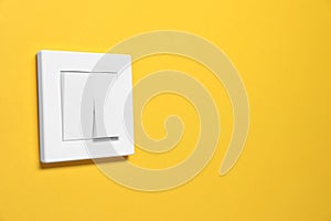 Modern plastic light switch on orange background. Space for text
