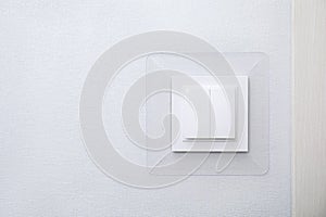 Modern plastic light switch on white wall, space for text