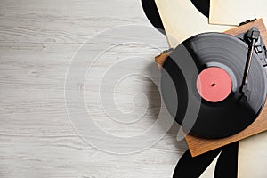 Modern player and vinyl records on white wooden background, flat lay. Space for text