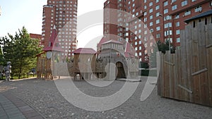 A modern playground in an ecological green residential complex in the summer. Dolly camera