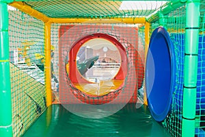 Modern playground indoor. Kids jungle in a play room. Round tunnel in children gym.