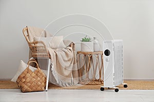 Modern portable electric heater near furniture indoors