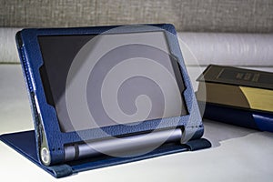 Modern portable equipment. The Lenovo Yoga tablet with a support in a cover of blue color.