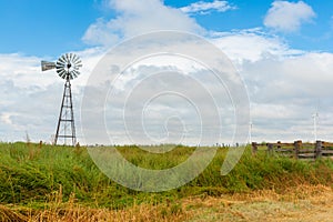 Modern power windmills andold fashioned pump windmill in field, on Route 66 Texas, USA