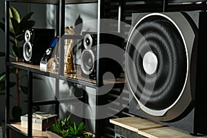 Modern powerful audio speaker system on shelving indoors
