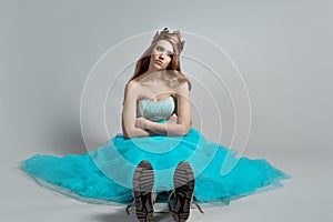 Modern princess, beauty in a crown and a lush blue dress and sneakers,
