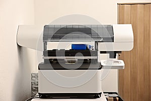 Modern printer and empty bottle in room