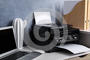 Modern printer, laptop and decor element on white table