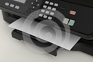 Modern printer with paper on white table, closeup