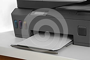 Modern printer with paper on white table, closeup