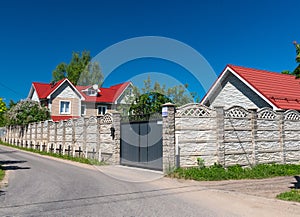 Modern private house behind the fence in summer
