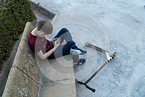 Modern problems of children. The child plays with the phone in the park