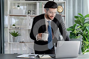 Modern professional businessman at modern office desk with coffee. fervent