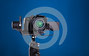 Modern professional video camera on blue
