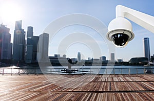 Modern public CCTV camera on wall with blur building background.