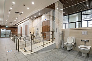 Public disabled restroom with handrails and accessibility features photo