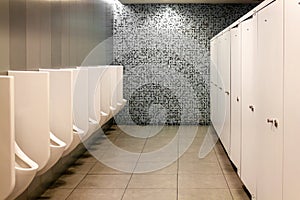 Modern public toilet for men. Clean and hygienic urinal from white tiles. Public men`s toilet