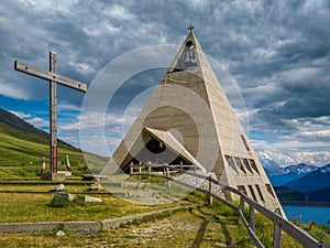 Modern pyramid shaped church and alpine lake in France