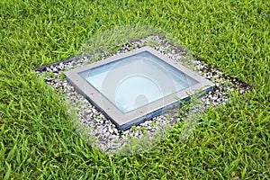 Modern quadrangular metal spotlight led lamp for outdoor use with square shape recessed in a grass floor