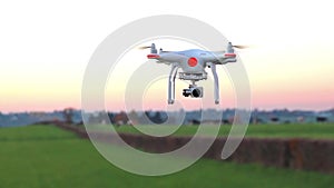 Modern RC UAV Drone / Quadcopter with camera flying on a clear s