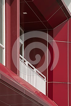 Modern red balcony of the building architecture with white aluminium window and metal fence