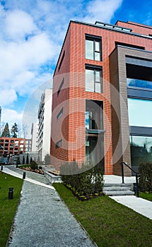 Modern Red Brick Apartment Complex with solid rock fence wall. Home residential buildings complex real estate