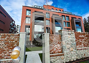 Modern Red Brick Apartment Complex with solid rock fence wall. Home residential buildings complex real estate