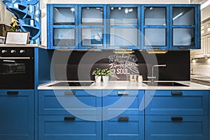 Modern red kitchen interior with black brick walls, wooden countertops with a built in sink and a cooker