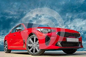 Modern red luxury car under the cloudy sky
