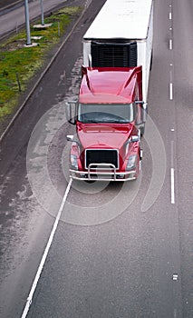 Modern red semi truck with refrigerator unit on reefer trailer d