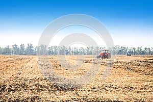 Modern red tractor in the field.