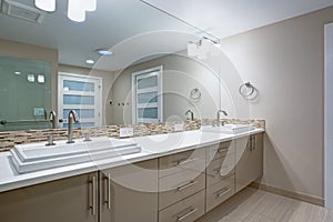 Modern refreshing bathroom with a beige dual washstand.