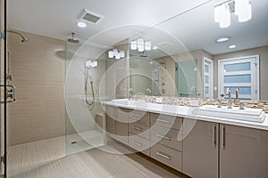 Modern refreshing bathroom with a beige dual washstand. photo
