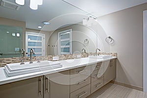 Modern refreshing bathroom with a beige dual washstand. photo