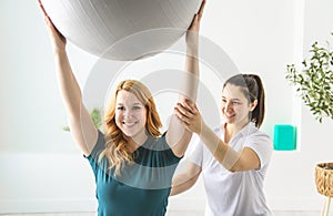 Modern rehabilitation physiotherapy at work with client using training ball