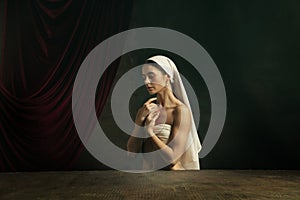 Modern remake of classical artwork. Young medieval woman on dark background photo