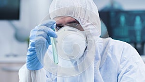 In modern research facility scientist is looking at a green sample