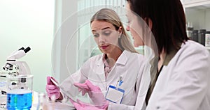 Modern research laboratory, two female scientists work with digital tablet and analyze samples of biochemical substances