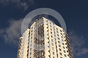 Modern residential building against blue sky with clouds.