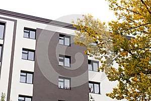 Modern residential building with new apartments and autumn tree