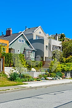 Modern residential houses on the street with landscaped front yards on terraces.