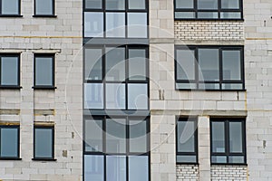 Modern residential multi-storey building. Windows and balconies on a new residential building close-up. Buying and selling