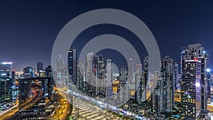 Modern residential and office complex with many towers aerial night timelapse at Business Bay, Dubai, UAE.