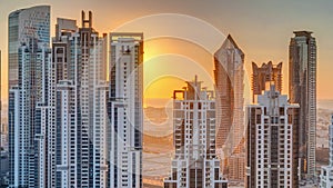 Modern residential and office complex with many towers aerial timelapse at sunset in Business Bay, Dubai, UAE.