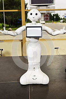 Modern Robotic Technologies. Electronics Show-exhibition of consumer electronics. The robot shows emotion. Raises hands upward, photo