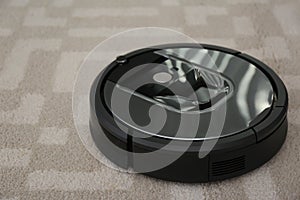 Modern robotic vacuum cleaner on carpet